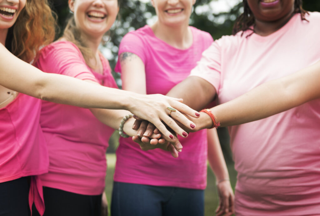 Mulheres na luta pela prevenção do cancêr de mama, com as mãos unidas
