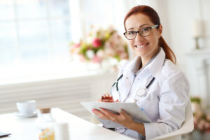 Médica sorrindo em seu consultório, cuidando da saúde da mulher